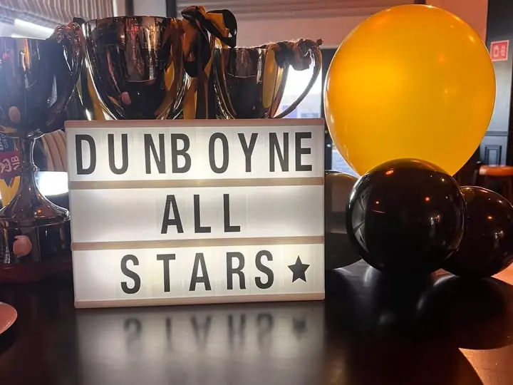 A Dunboyne All Stars sign beside trophies and balloons in the clubhouse