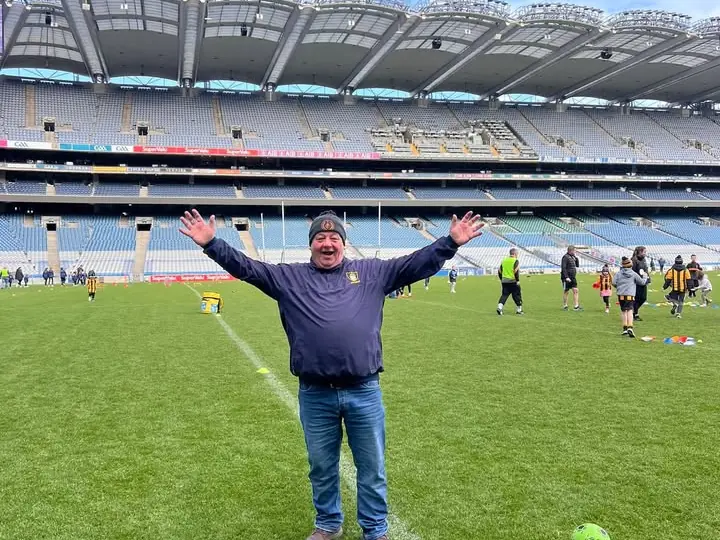 A coach with arms outstretched on the pitch in Croke Park