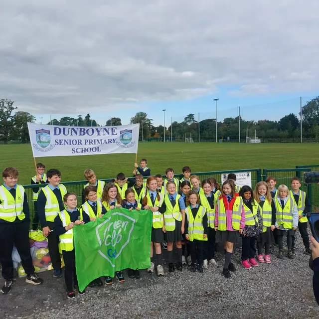 Dunboyne Senior Primary School pupils holding a GAA Green Club flag at the club